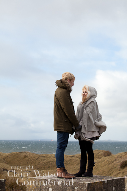 couple looking at each with sea behind